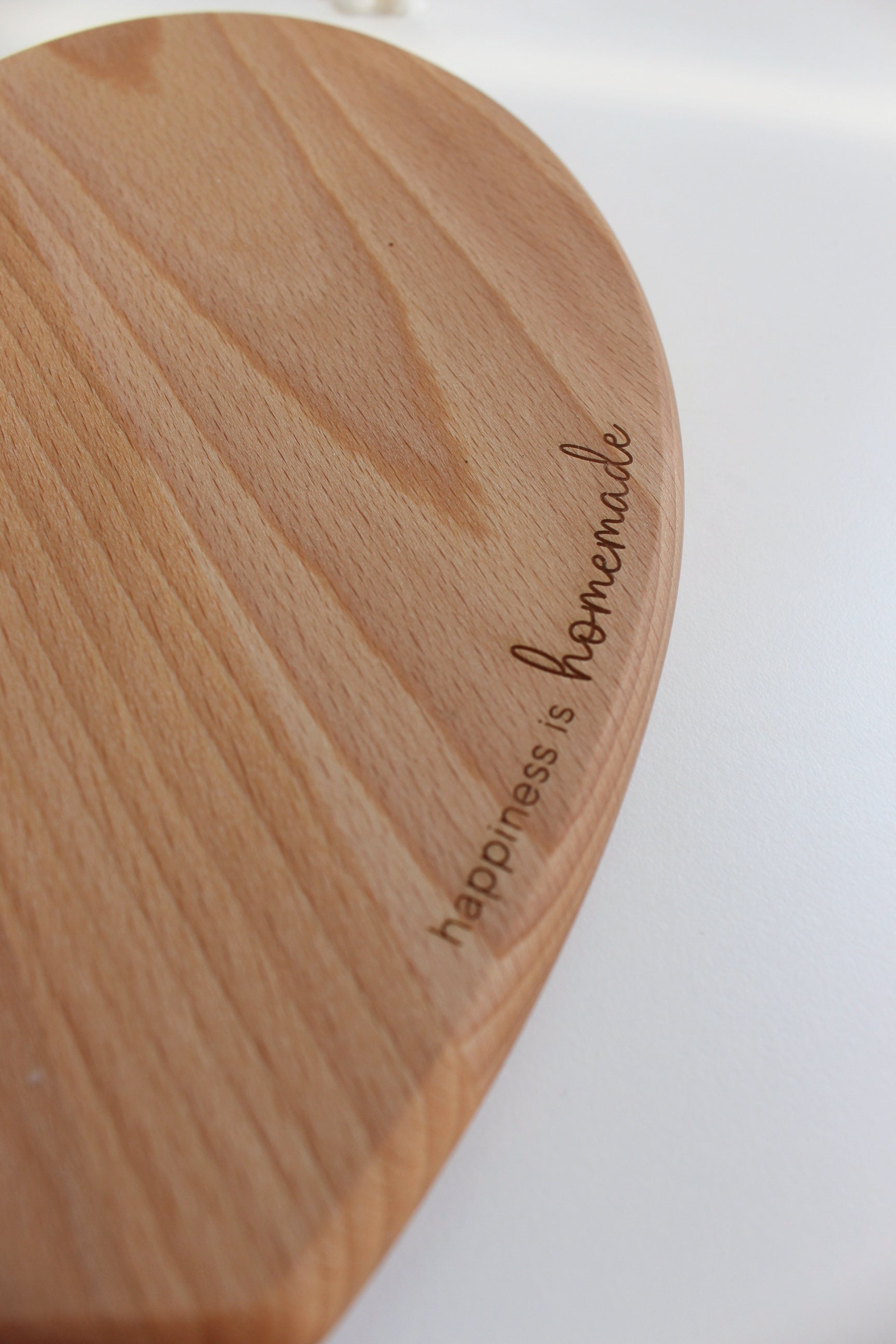 Herzförmiges Holzschneidebrett - "happiness is homemade"